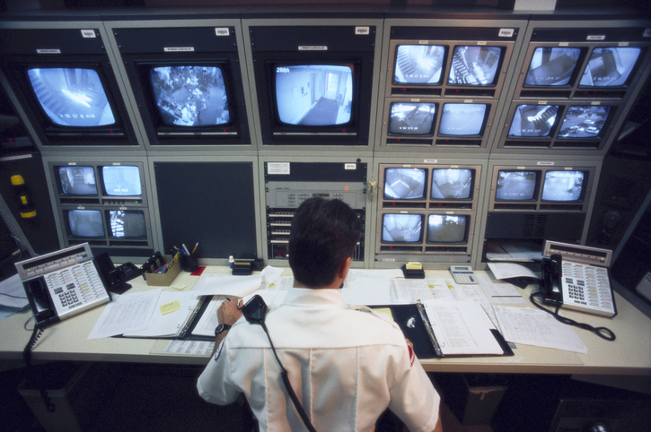Security specialist monitoring computer cameras