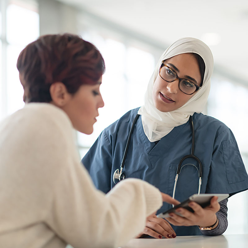 Doctor wearing hijab speaking with patient